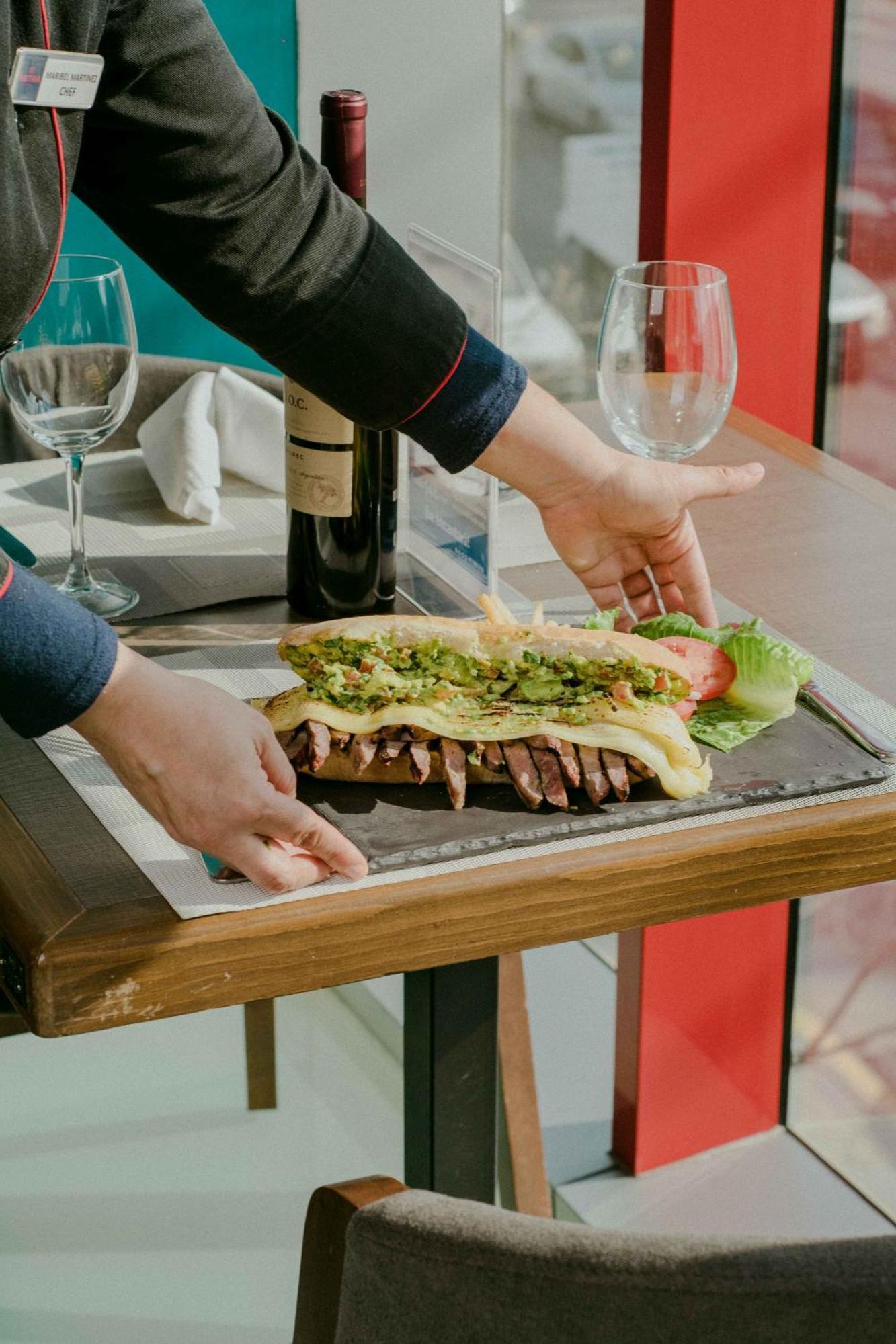 Metria Hotel Леон Экстерьер фото A waiter serving a steak